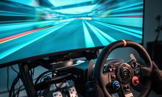 A sim racing wheel and monitor showing a multiplayer circuit race in a home racing rig